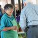 Dolores Gracia, of Gracias' Greenhouse, smiles as she chats with a customer at the Ann Arbor Farmers Market on the first Wednesday morning market of the season.  Melanie Maxwell I AnnArbor.com